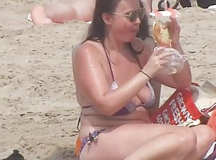 Busty mature lady has a lunch on the beach