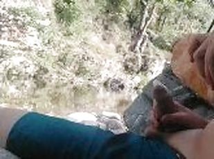 Boy playing with himself in a condom near a river